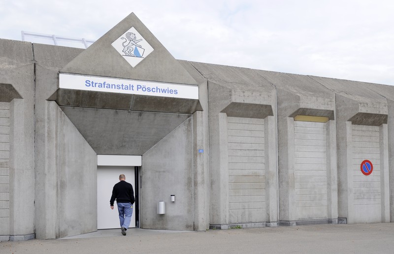 Ein Mensch geht auf das Eingangstor der Strafanstalt Pöschwies zu.