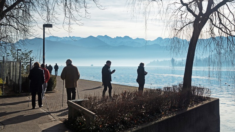 Menschen flanieren am Vierwaldstättersee