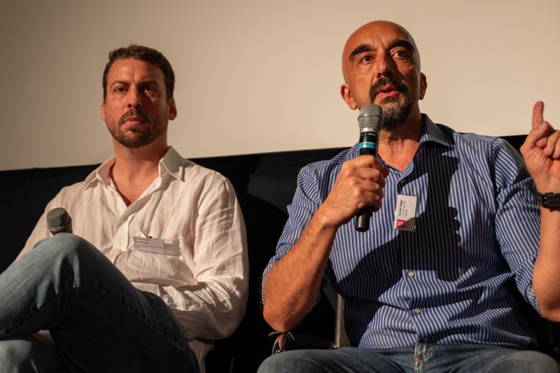 Jan Tschannen von der Linsi Foundation und Davide Naggi, Landesdirektor des HEKS in Uganda sitzen nebeneinander auf einem Podium.