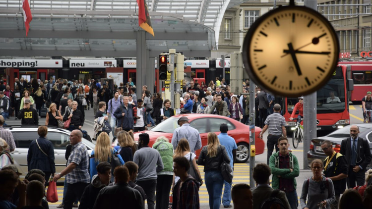 Viele Menschen unter einer Uhr im Bahnhof Bern