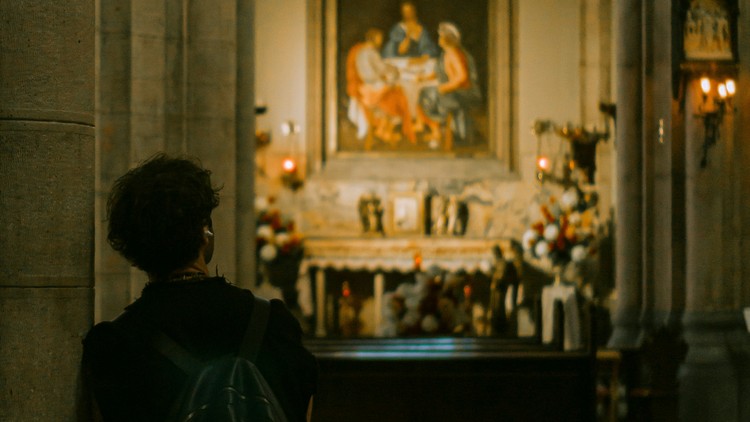 junger Mann betrachtet ein Bild in einer Kirche