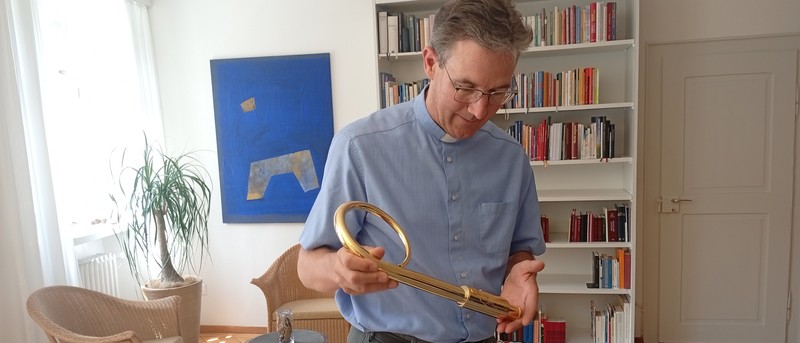 Bischof Beat Grögli betrachtet seinen goldenen Hirtenstab.