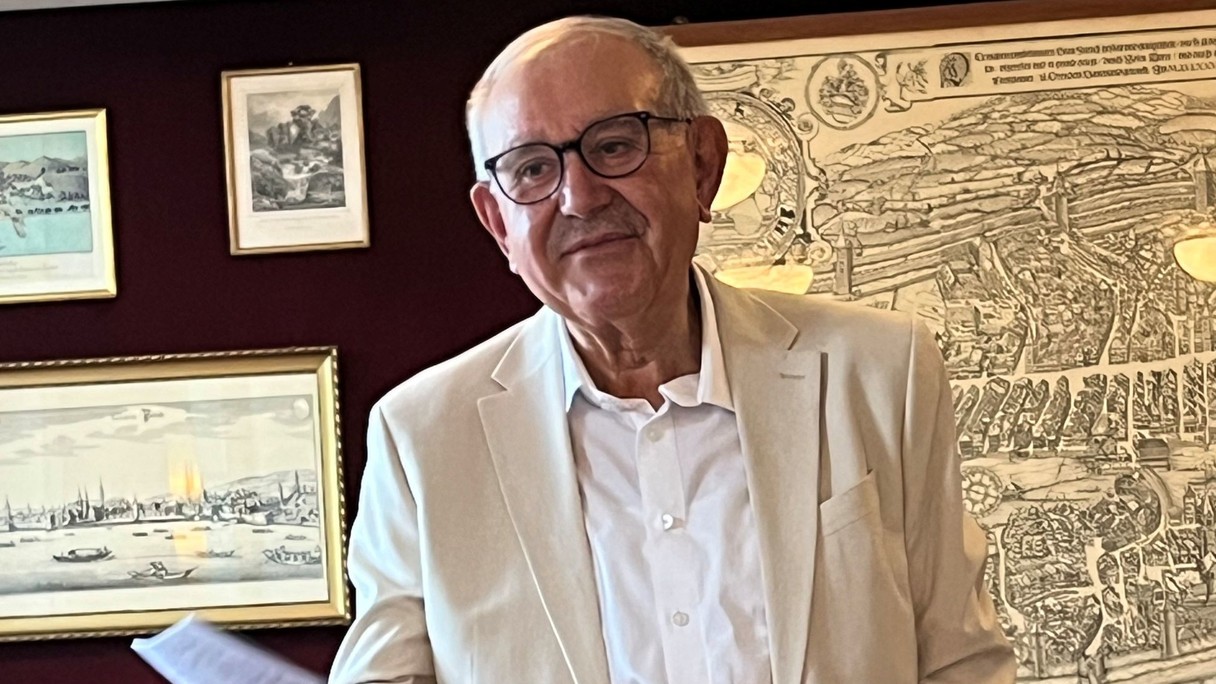 Hans Hollenstein an der Buchvernissage, im Hintergrund sind Stiche zu sehen