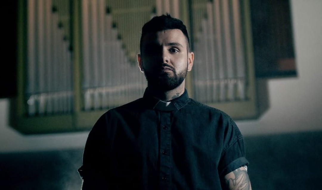 Host Livio Carlin steht in einer Kirche, im Hintergrund ist die Kirchenorgel zu sehen