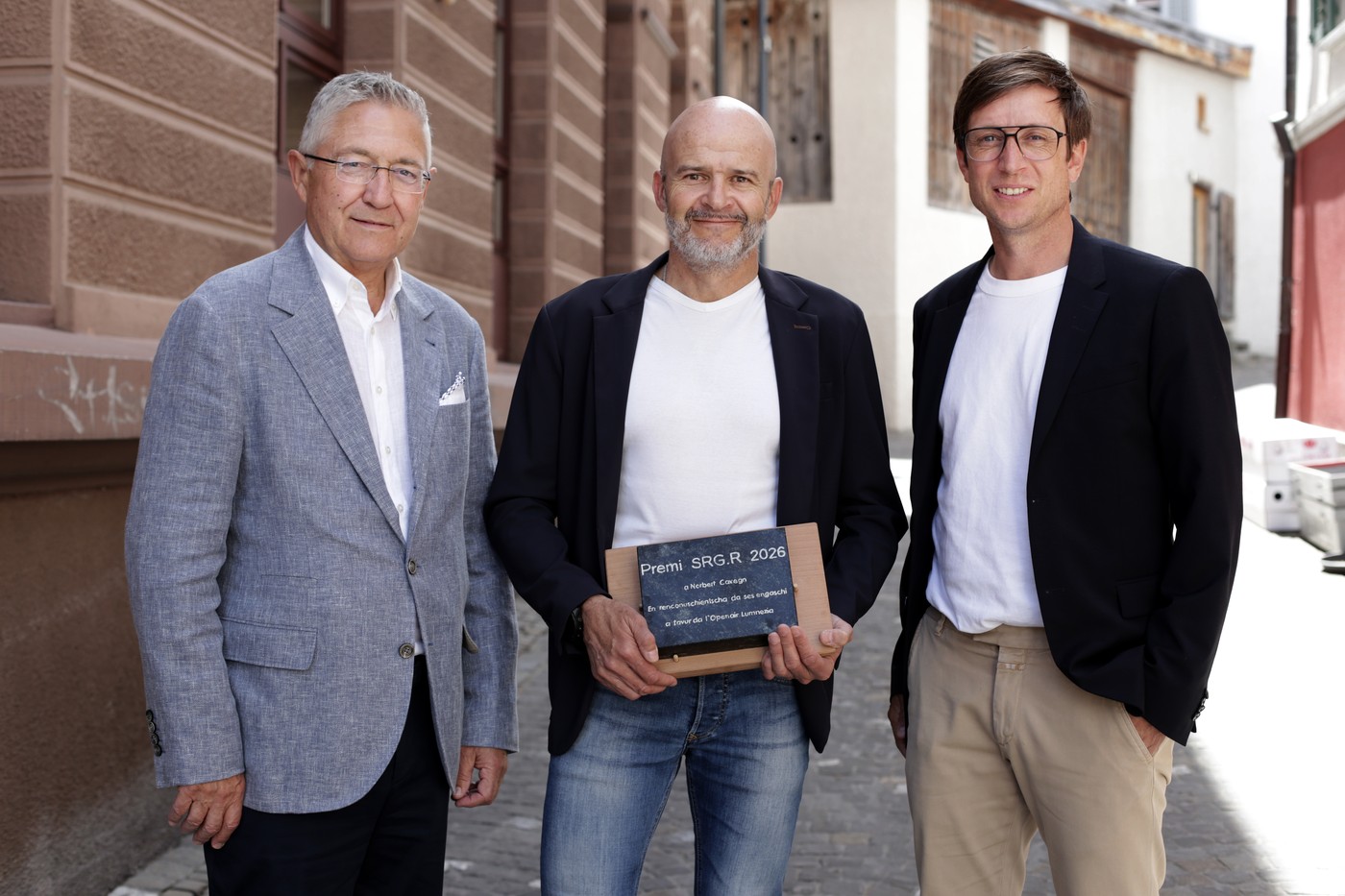 da sanester: Vincent Augustin, president SRG.R, Norbert Cavegn, porta-premi e Roman Flepp, laudatur