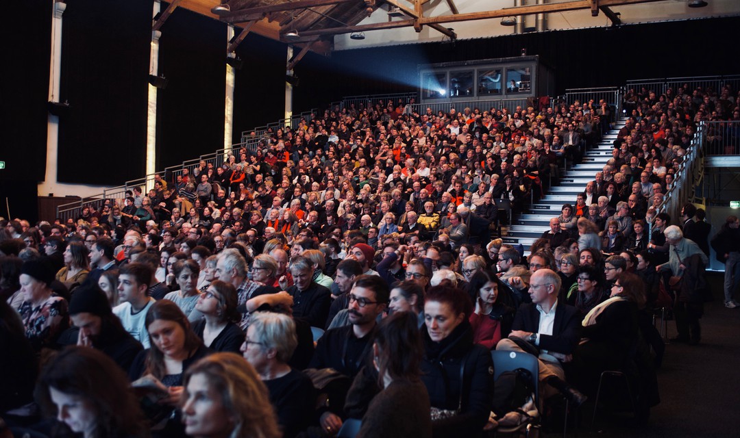 Das Publikum wartet im Kinosaal, bis der Film beginnt