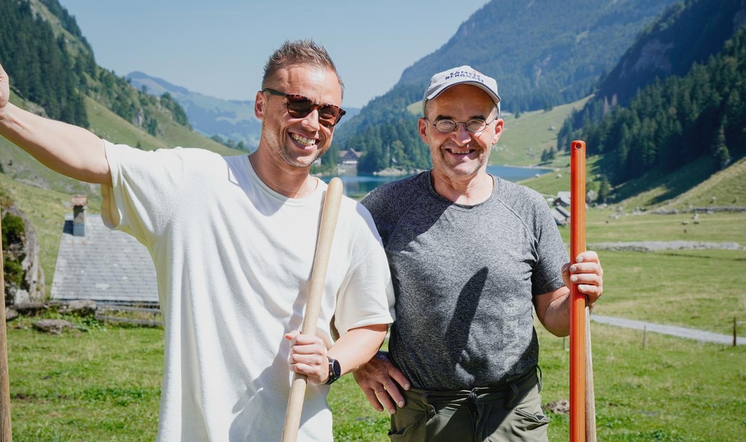 Jan Fitze steht mit einem Bauern in einem Tal