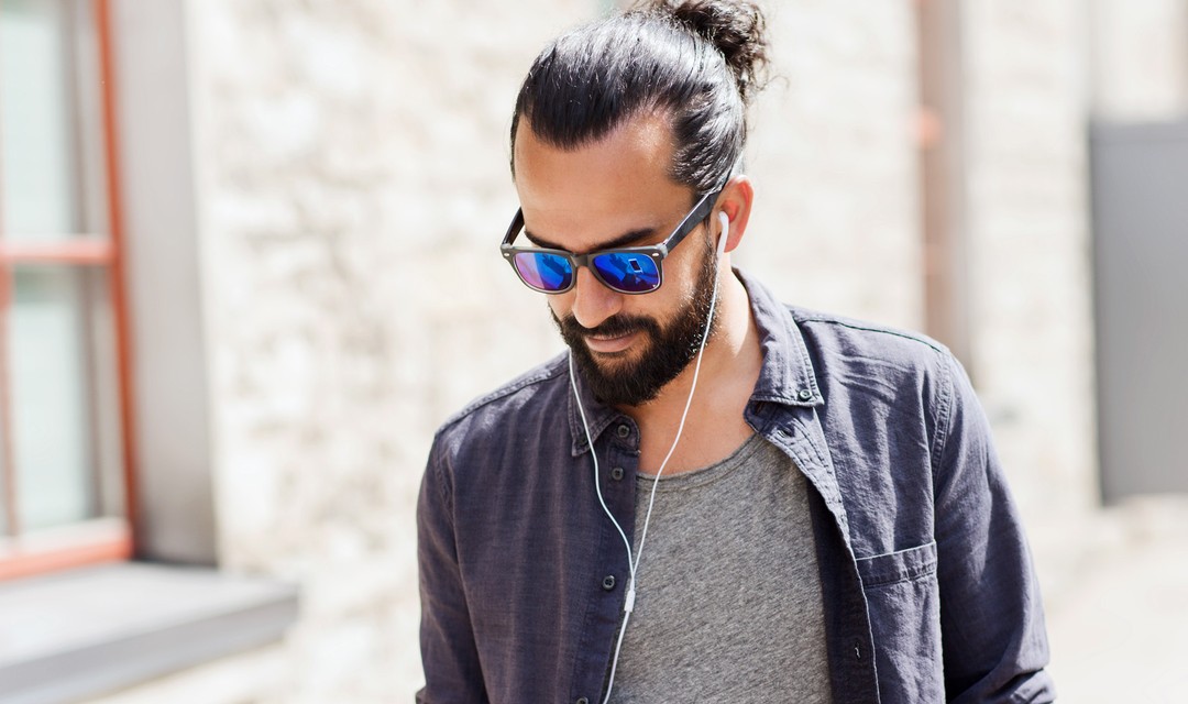 EIn Mann läuft durch die Strasse und hört sich einen Podcast an