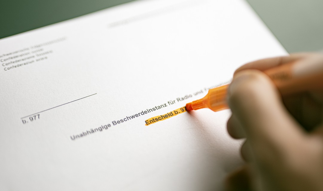 Symbolbild, jemand markiert etwas auf einem Ubi-Bericht