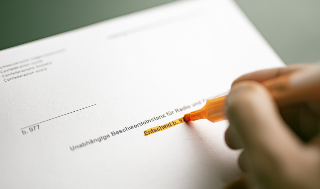 Foto eines UBI-Berichts, auf dem jemand etwas markiert