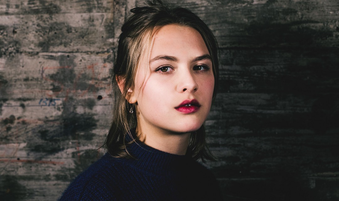 Frau mit mittellangen braunen halb zusammengenommen Haaren