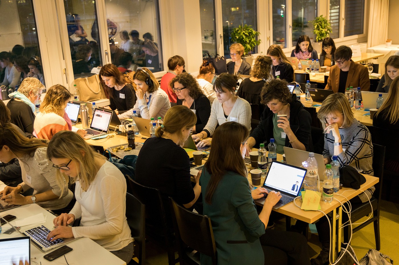 Viele Frauen arbeiten in einem Raum am Computer und erfassen neue Wikipedia Biografien