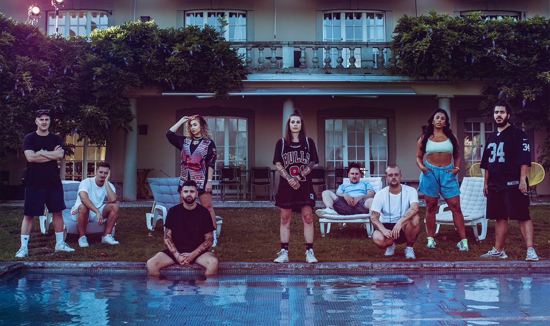 Beide Teams von Battle Mansion stehen vor einer Villa mit Pool