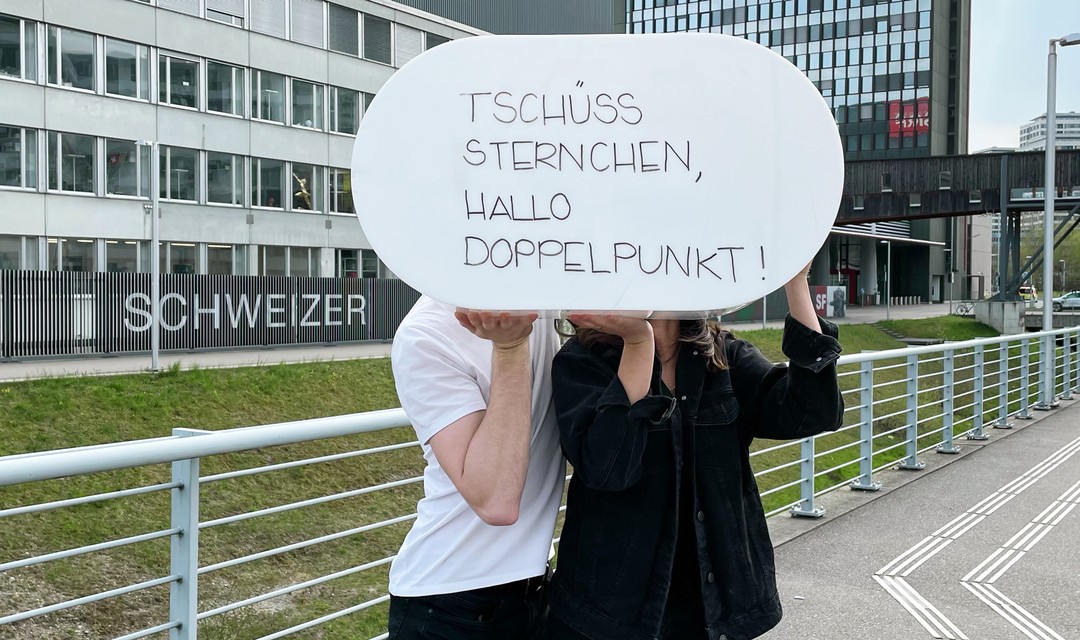 Ein Mann und eine Frau halten einen Leuchtkasten: «Tschüss Sternchen, hallo Doppelpunkt»