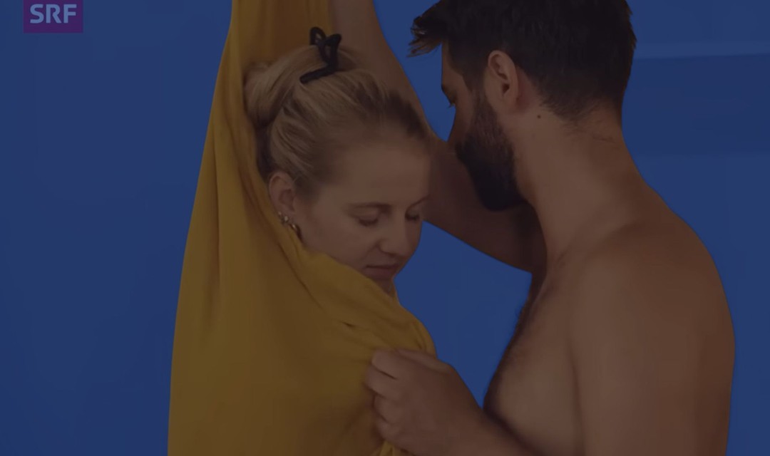 Das Foto zeigt ein Mann, der eine Frau im Stehen mit einem Tuch massiert