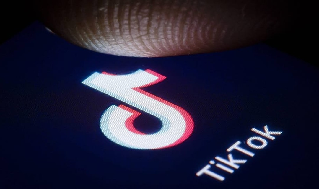 Ein Finger tippt auf einen Screen mit einem TikTok-Logo