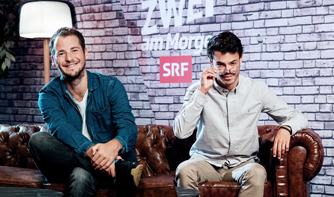 Produzent David Meury und Philip Wiederkehr auf einem Sofa und blickt in die Kamera.