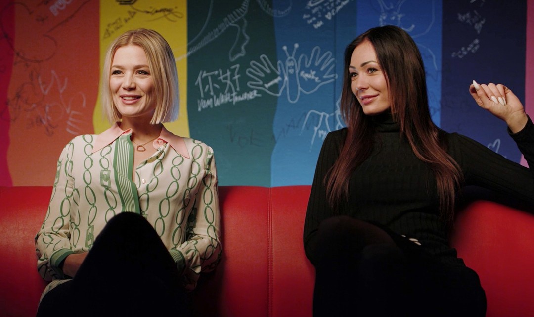 Dominique Rinderknecht und ihre jüngere Schwester Noemi sitzen nebeneinander auf einem Sofa