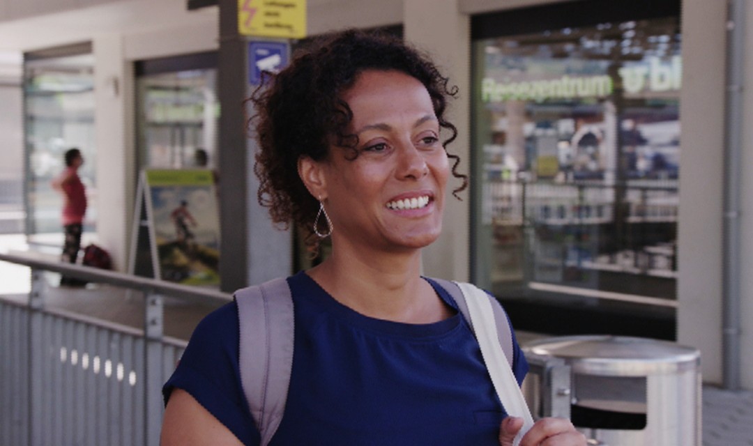 Angélique Beldner mit dem Rucksack unterwegs am Bahnhof