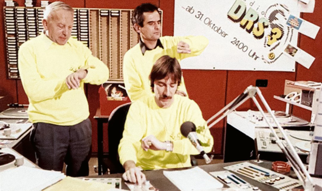 Der Sendestart von DRS 3 am 1. November 1983 um 0:01 Uhr: Der damalige SRG-Generaldirektor Leo Schürmann, Radiodirektor Andreas Blum und DRS 3-Chef Peter Bühler (v. l.) blicken gespannt auf ihre Armbanduhren.