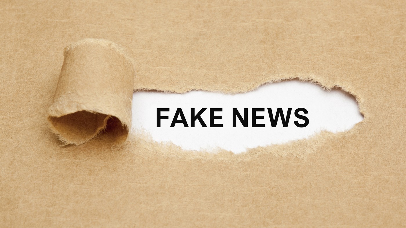 ake News appearing behind ripped brown paper.