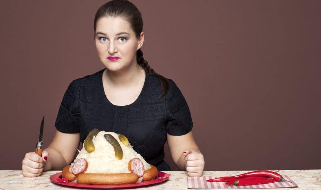 Ágota Dimén vor einem Teller Sauerkraut mit Würsten