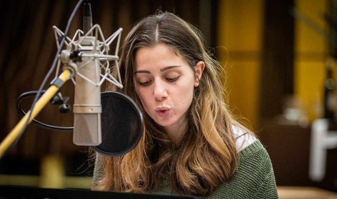 Aysima Ergün steht im Tonstudio vor dem Mikrofon