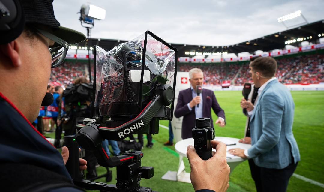 Bild eines Kamermannes, welcher ein Fussballspiel filmt